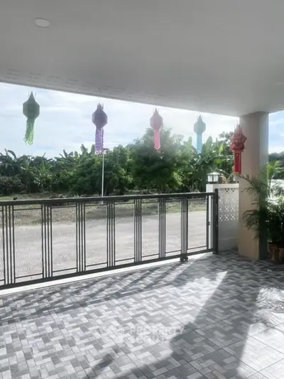 Spacious balcony with decorative lanterns and scenic greenery view.