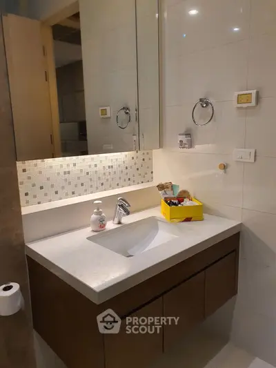 Modern bathroom with sleek vanity and mirror in stylish apartment.