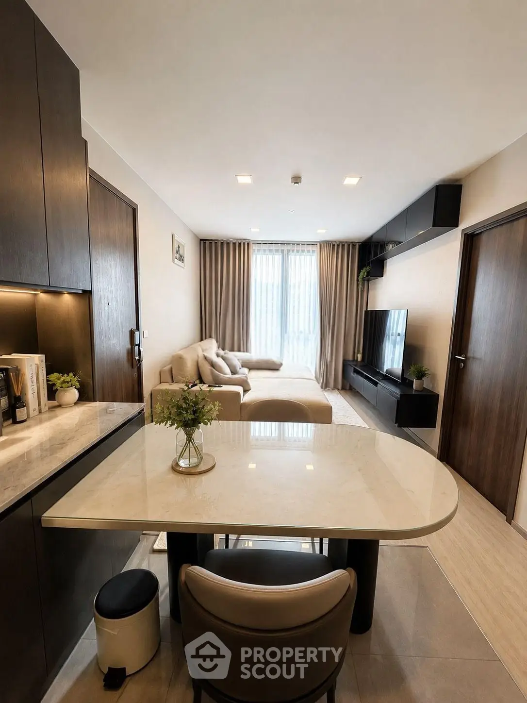 Modern living room with sleek furniture and open layout, featuring a cozy sofa and stylish decor.