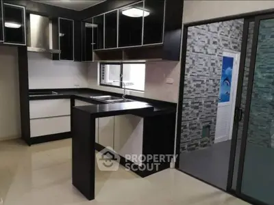 Modern kitchen with sleek black and white cabinetry and open layout