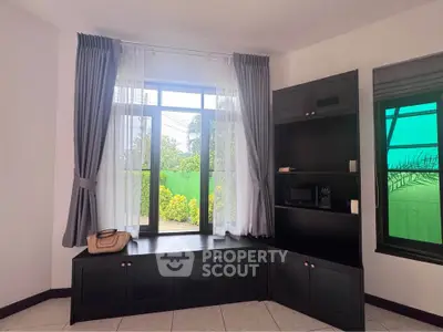 Charming corner unit with large windows and built-in storage, offering a serene garden view.