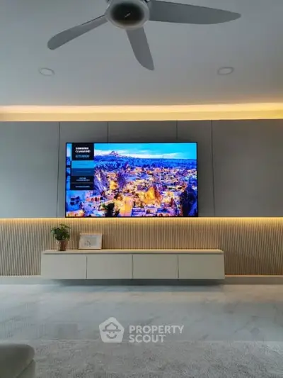 Modern living room with large TV and stylish lighting