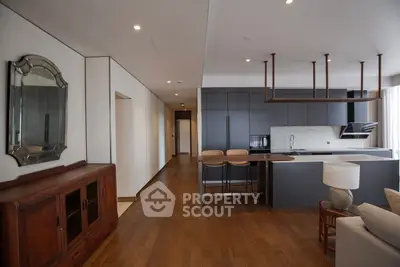 Modern open-plan kitchen and living area with sleek design and wooden flooring.