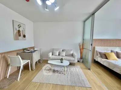 Modern living room with cozy seating and stylish decor adjacent to a bedroom.