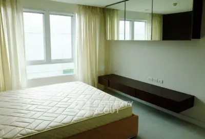 Spacious bedroom with large windows and modern furnishings