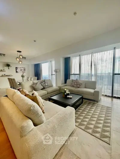 Spacious modern living room with elegant decor and large windows offering stunning views.