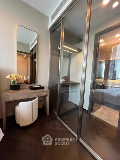 Luxurious bedroom with elegant vanity and walk-in closet, featuring modern design and sophisticated decor.