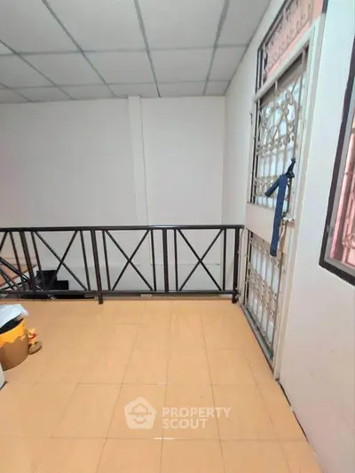 Cozy balcony with tiled flooring and metal railing, perfect for relaxation.