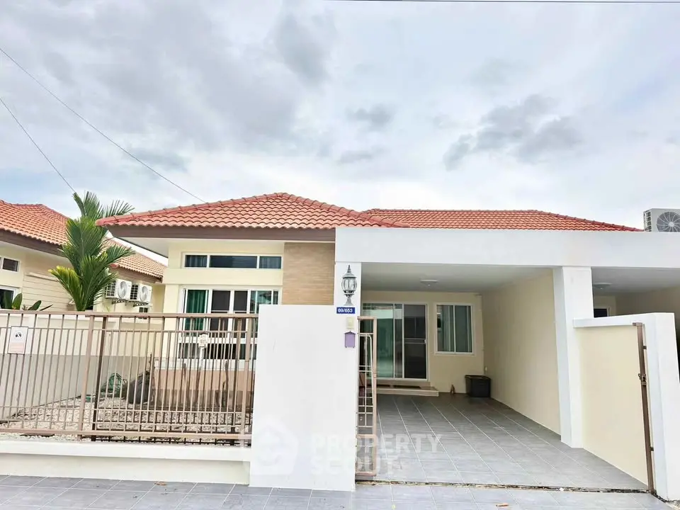 Charming single-story house with red-tiled roof and spacious driveway in a serene neighborhood.
