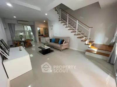 Spacious modern living room with elegant staircase and natural light