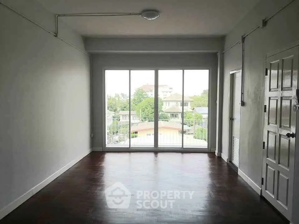 Spacious empty room with large windows offering a scenic view, perfect for customization.