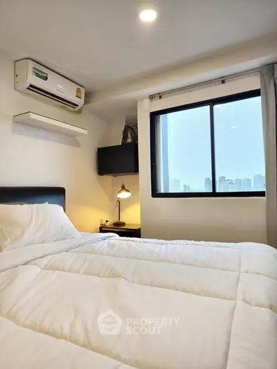 Cozy bedroom with city view, featuring a comfortable bed and modern air conditioning unit.