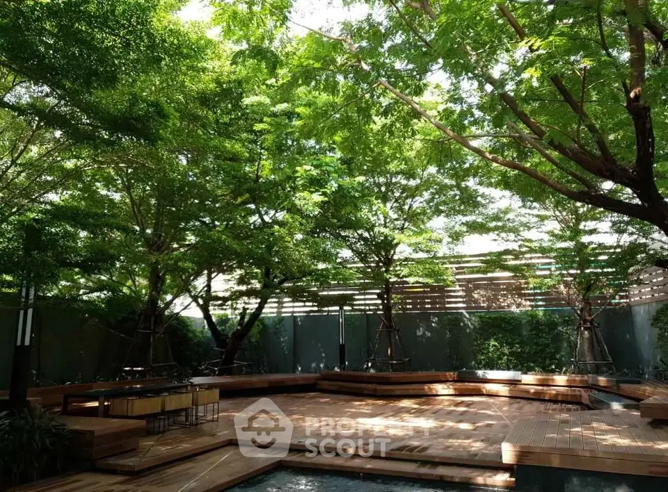 Serene garden with lush trees and wooden deck, perfect for relaxation.