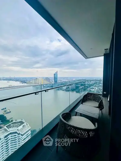 Stunning high-rise balcony with panoramic river view and modern outdoor seating.