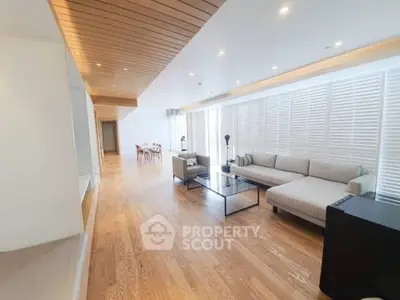 Spacious modern living room with wooden flooring and elegant furniture.