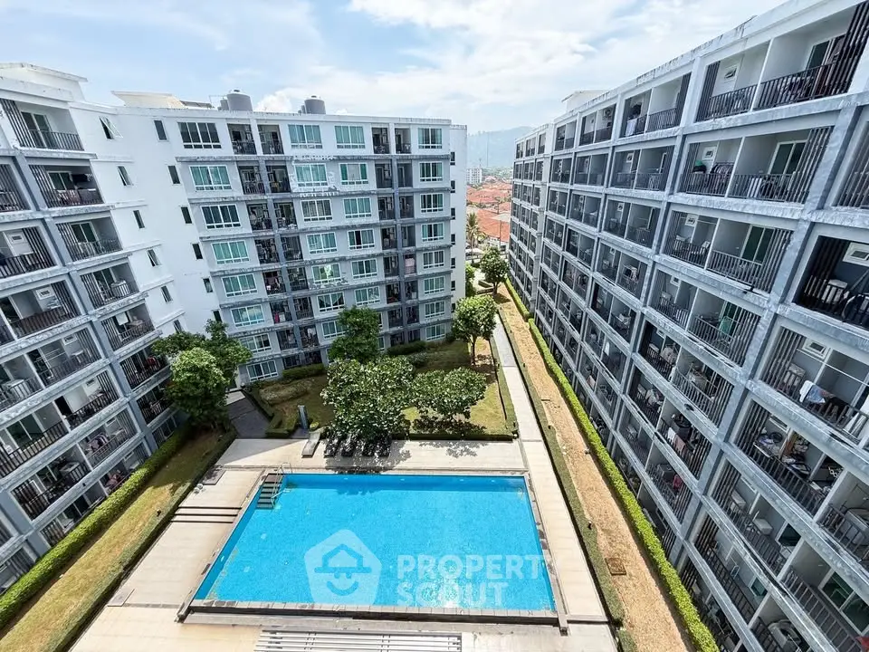 Modern apartment complex with central swimming pool and lush greenery, offering urban living with leisure amenities.