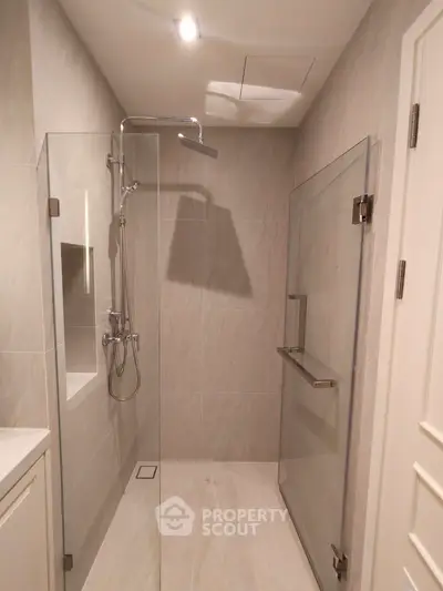 Modern bathroom with glass shower enclosure and sleek fixtures