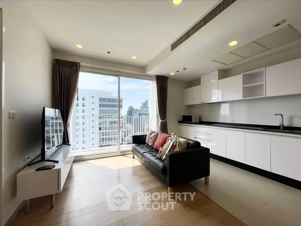 Modern living room with sleek kitchen and city view, featuring large windows and stylish decor.