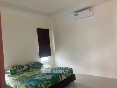 Cozy bedroom with modern air conditioning and stylish bedding in a minimalist design.