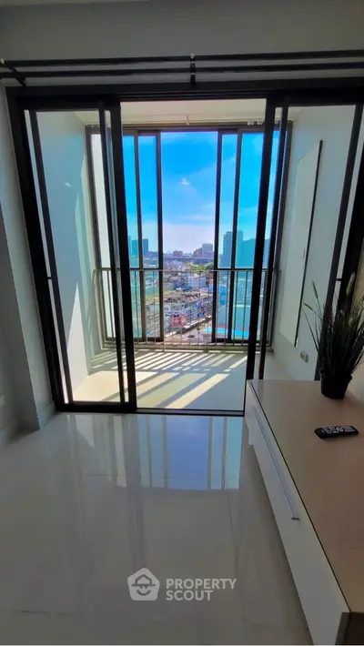 Stunning city view from modern apartment balcony with sleek glass doors.
