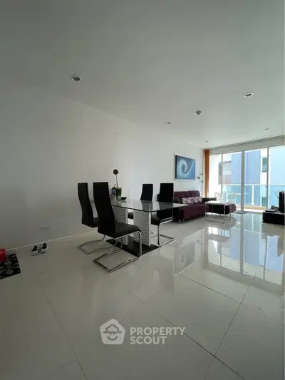 Modern living room with sleek furniture and large windows offering natural light.