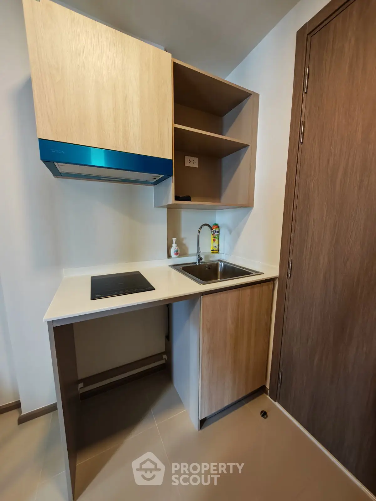 Modern compact kitchen with sleek cabinetry and built-in stove, ideal for efficient cooking in small spaces.