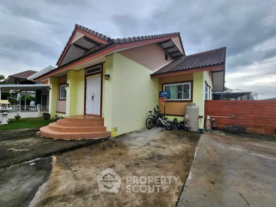 Charming single-story house with unique roof design and spacious driveway.