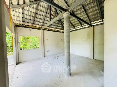 Spacious unfinished room with high ceiling and open window view