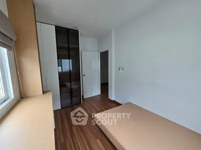 Modern minimalist bedroom with wooden flooring and built-in wardrobe