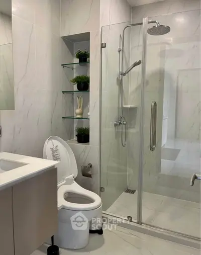 Modern bathroom with glass shower and sleek fixtures in contemporary home.
