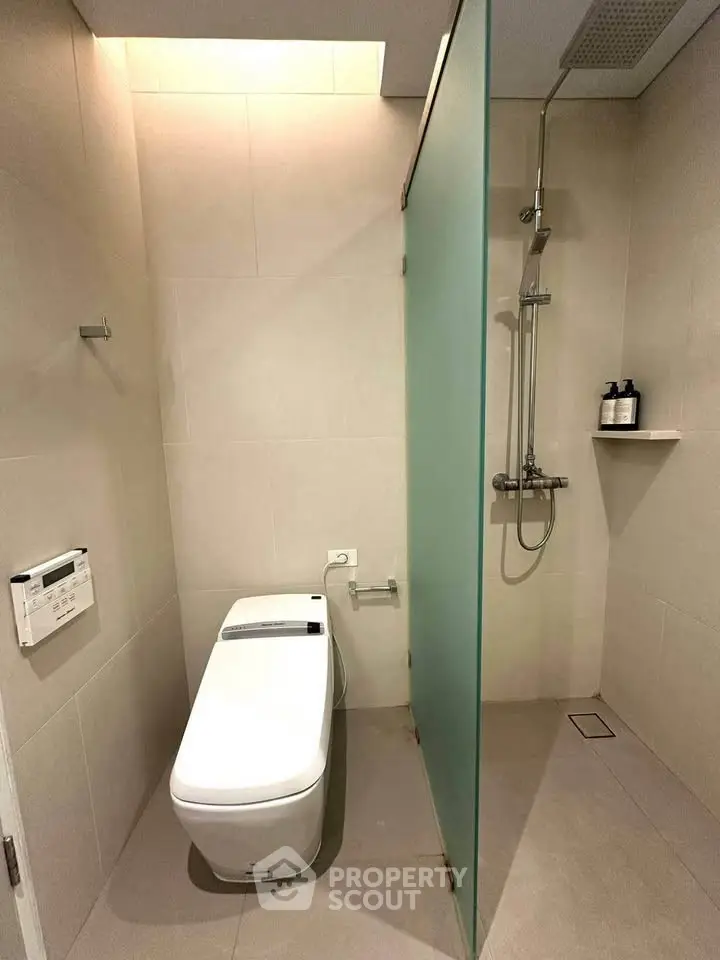 Modern bathroom with sleek toilet and glass shower partition