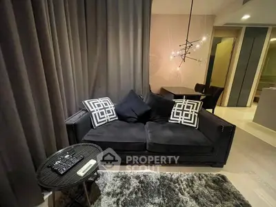 Modern living room with stylish black sofa and chic lighting