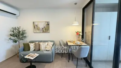 Modern living room with cozy seating and dining area, featuring stylish decor and natural light.