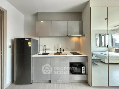 Modern compact kitchen with sleek cabinetry and integrated appliances in a stylish apartment.