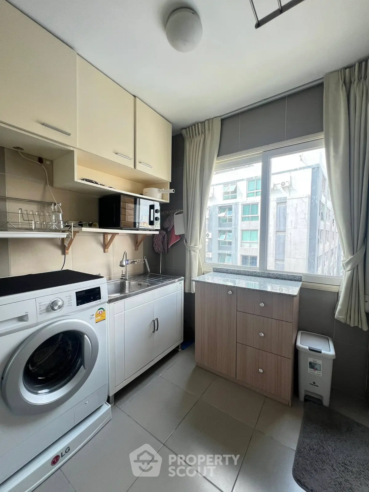 Modern laundry room with washing machine and ample storage in a high-rise apartment.