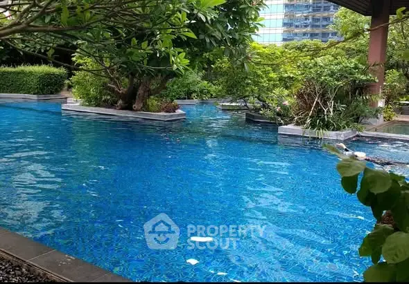 Luxurious residential pool surrounded by lush greenery and modern architecture.