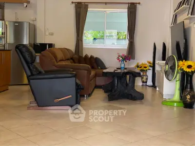 Spacious living room with cozy seating and unique wooden coffee table, perfect for relaxation and entertaining.