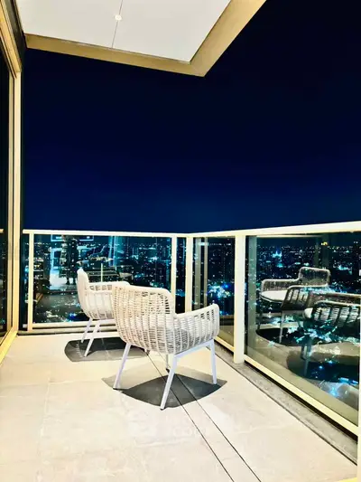 Luxurious balcony with stunning city skyline view at night, perfect for relaxation and entertainment.