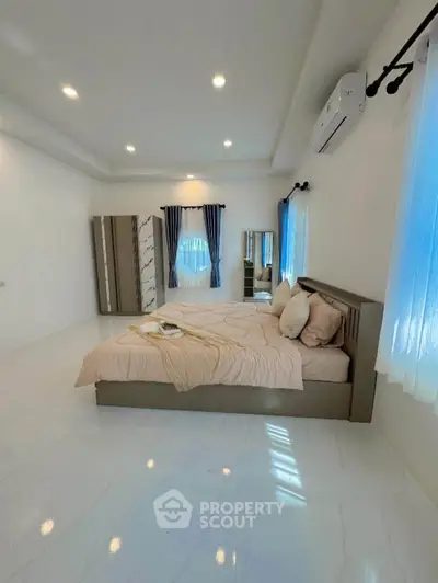 Spacious modern bedroom with elegant decor and natural light