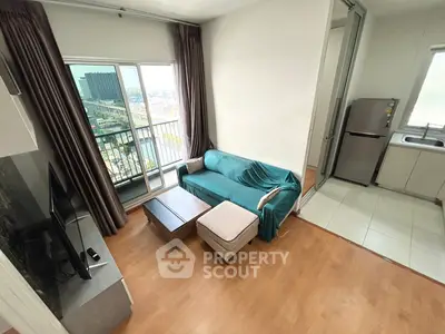 Modern living room with balcony view and adjacent kitchen in a stylish apartment.