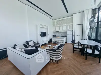 Luxurious open-plan living room with elegant decor and modern kitchen in a stylish apartment.