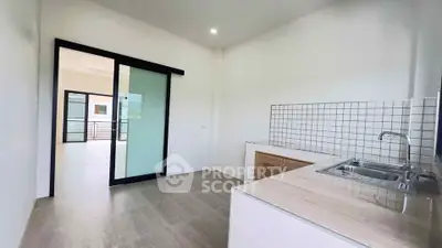 Modern kitchen with sleek design and open layout leading to bright living area.
