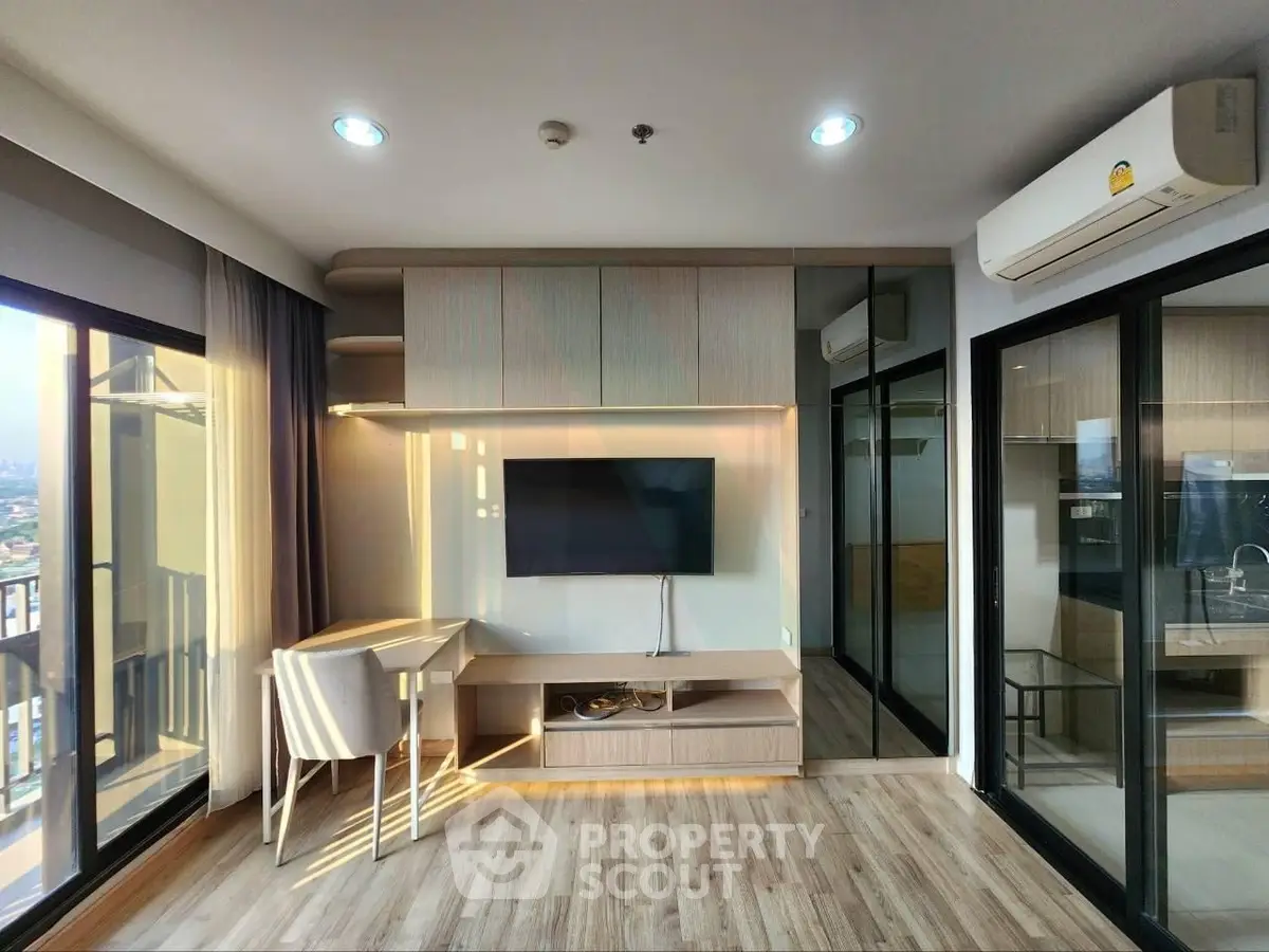 Modern living room with sleek furniture and large windows offering stunning city views.