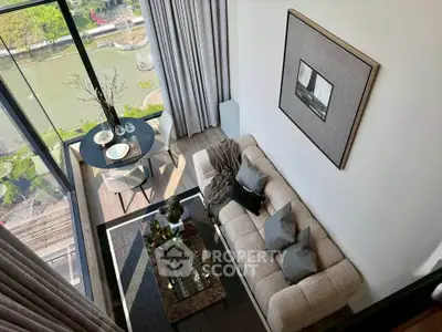 Modern living room with large windows and stylish decor overlooking a scenic view.