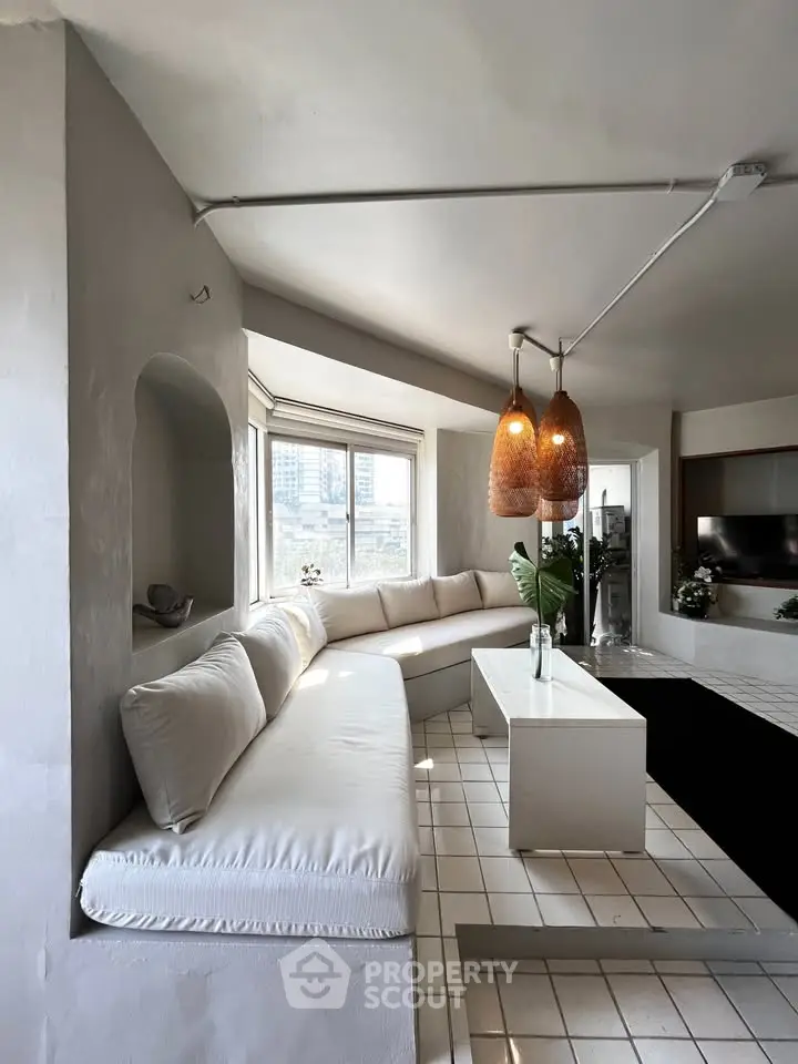Stylish living room with modern decor and large windows offering city views.