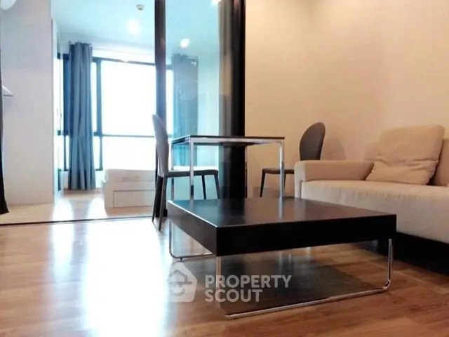 Modern living room with sleek furniture and wooden flooring in a stylish apartment.