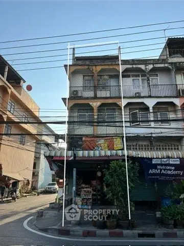 Charming multi-story building with street-level shops and residential units above, ideal for mixed-use investment.