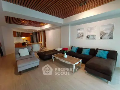Spacious living room with modern decor and open kitchen layout, perfect for entertaining.