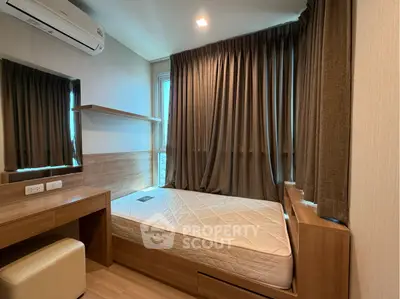 Cozy bedroom with modern wooden furniture and large window for natural light.