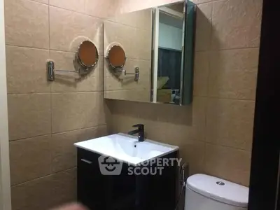 Modern bathroom with sleek vanity and wall-mounted mirrors in a stylish real estate property.
